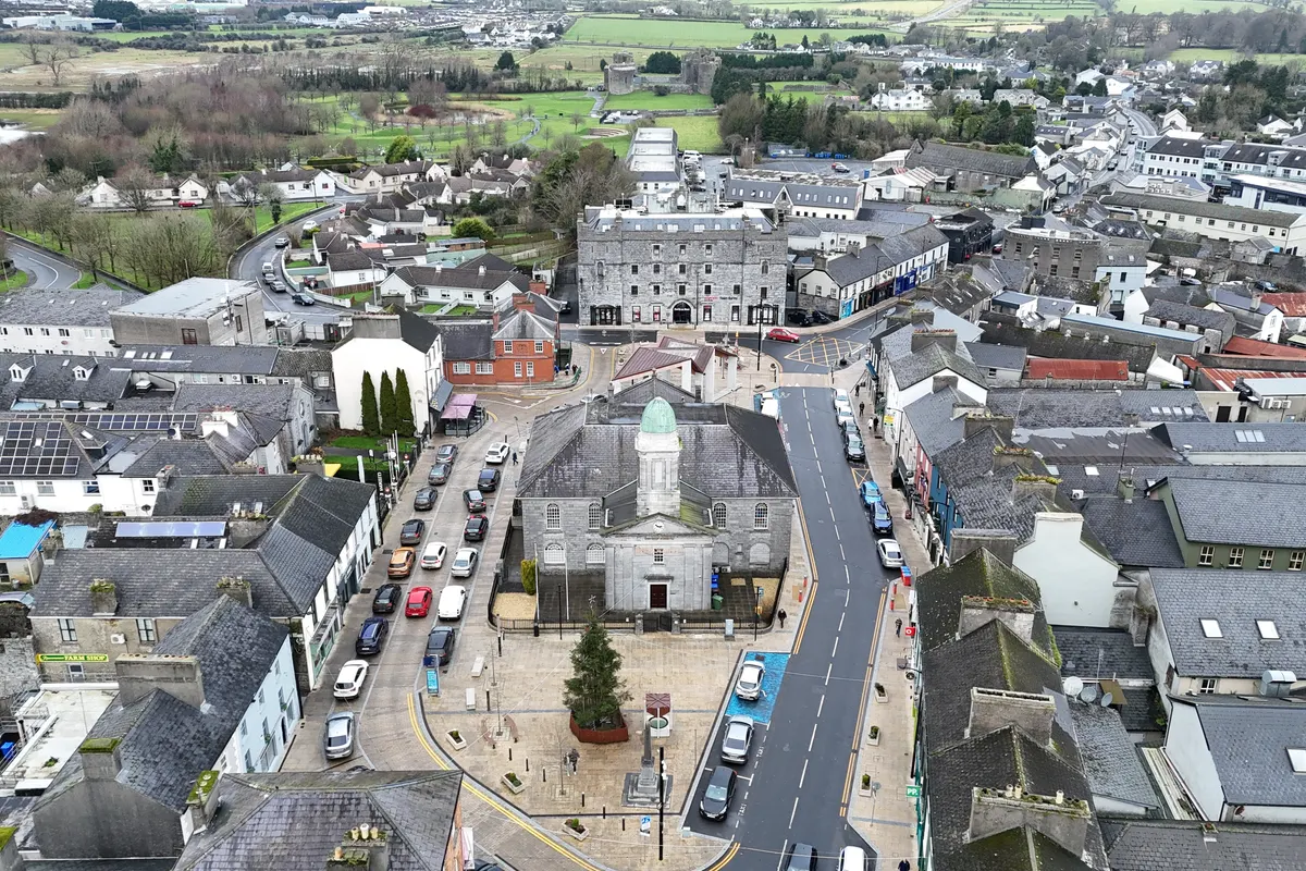 Aerial view over The Square in Roscommon town, with slate roofs, a cupola-topped stone building and green fields beyond